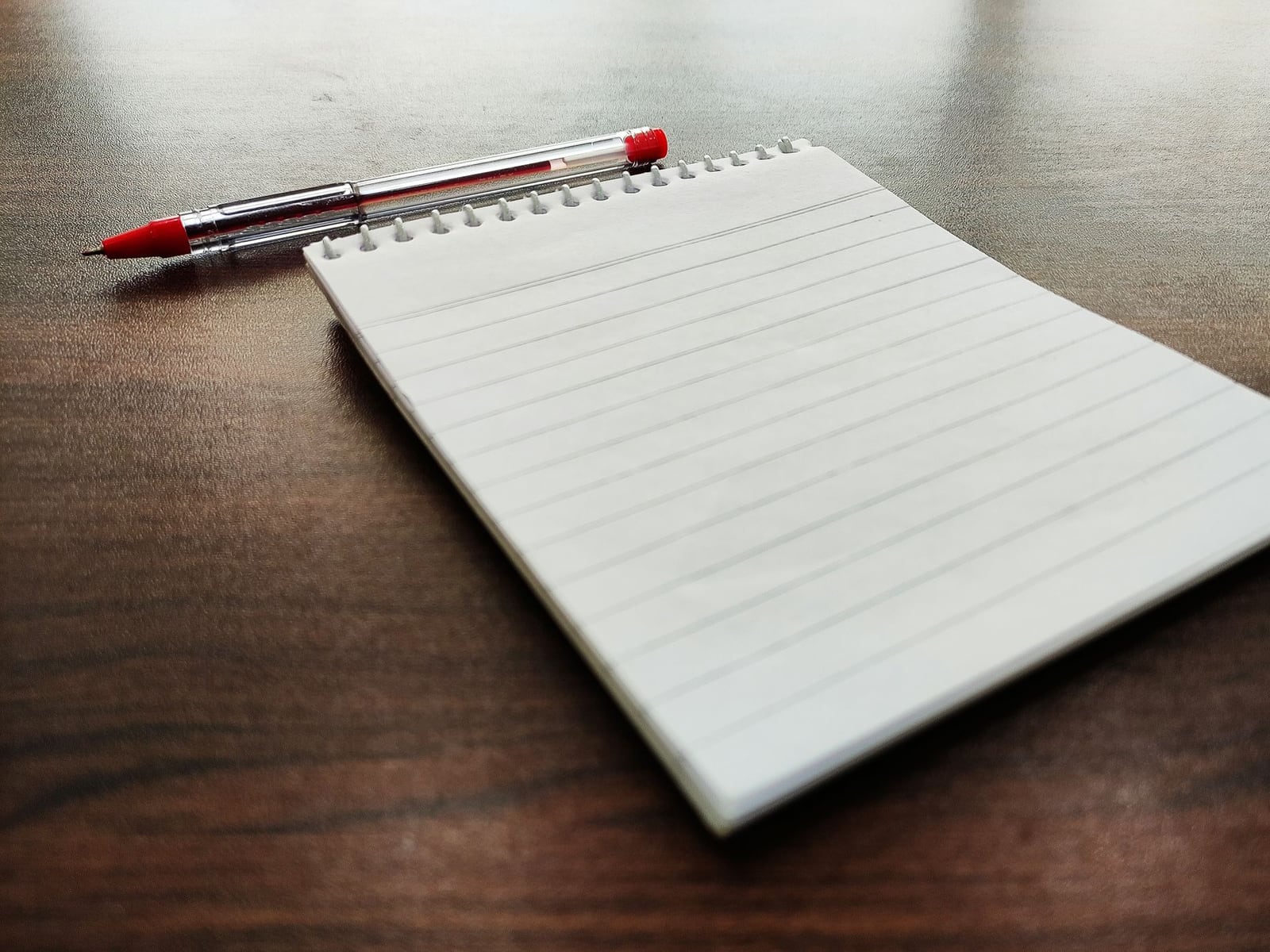 Macro shot of a red pen being used for professional proofreading and editorial corrections.
