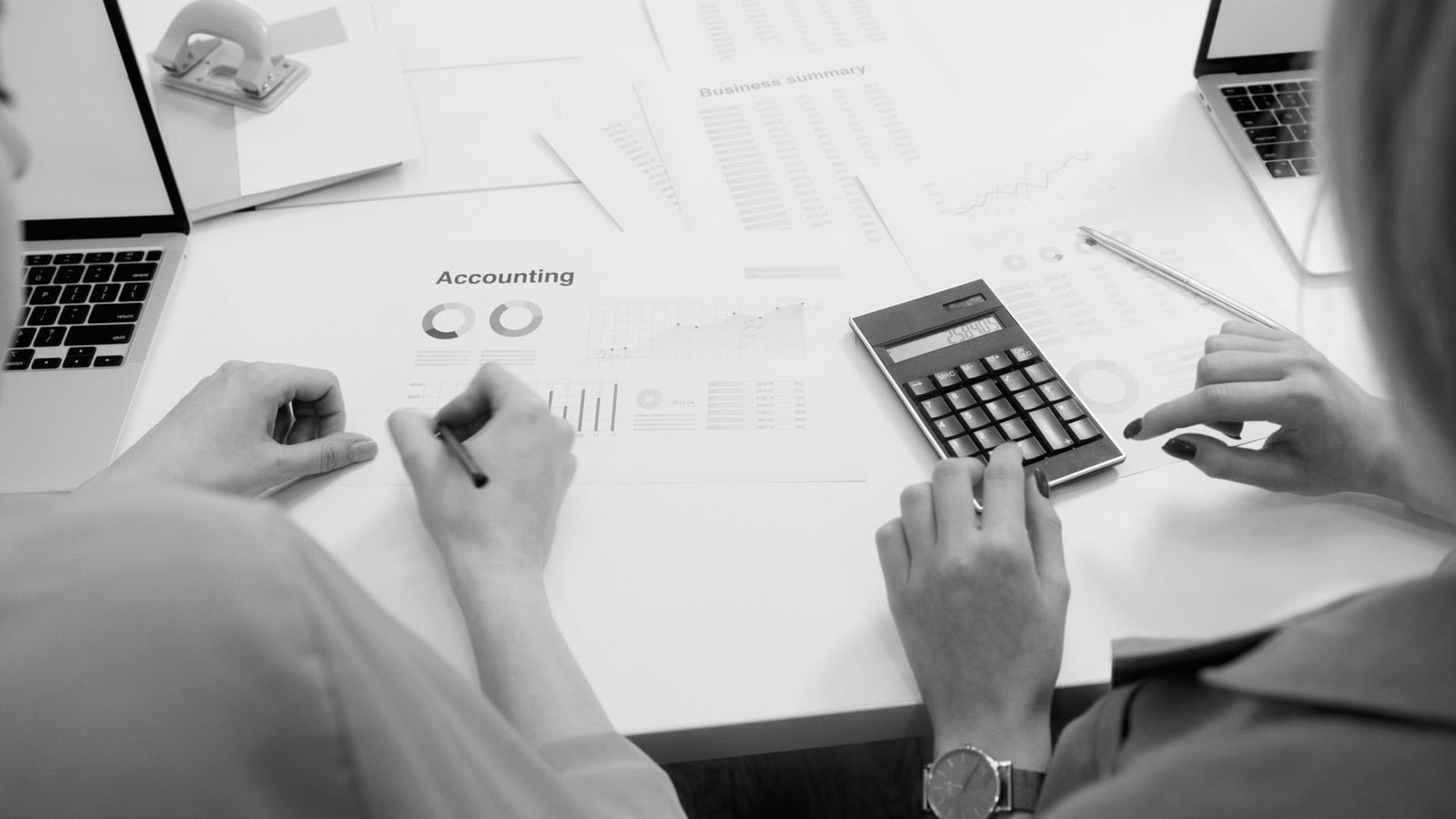 A calculator and professional documents on a desk representing content pricing.