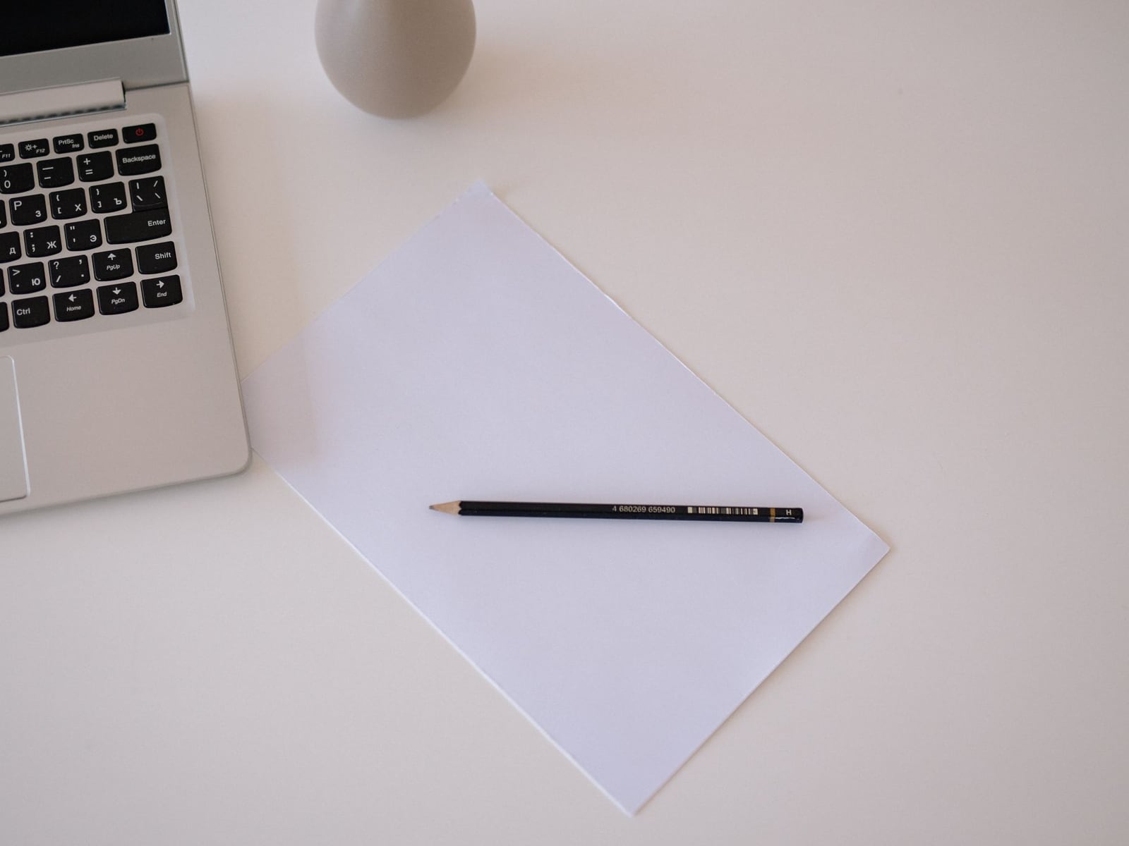 Close-up of a workspace with a laptop and printed drafts for website copywriting.